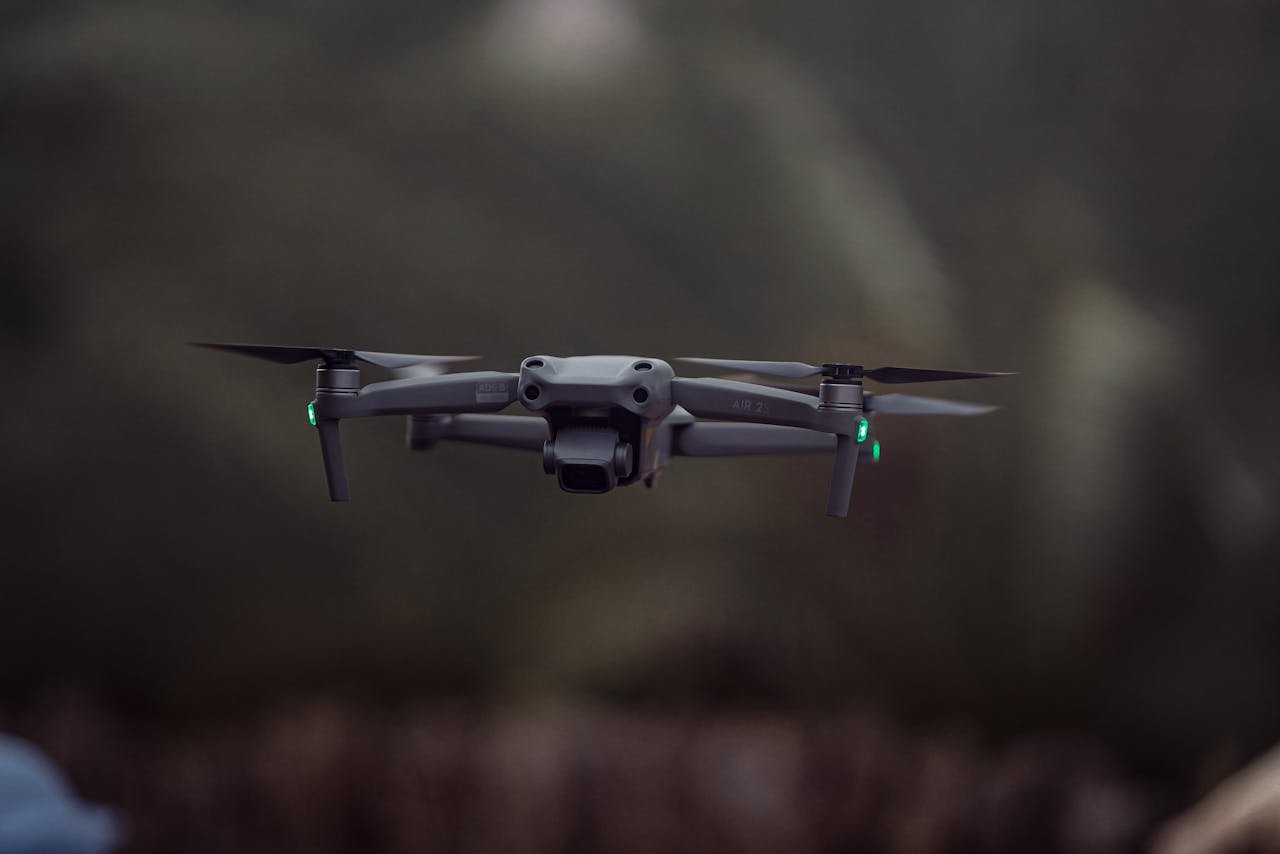 heros-img A quadcopter drone hovers outdoors with blurred background, displaying technology in action.